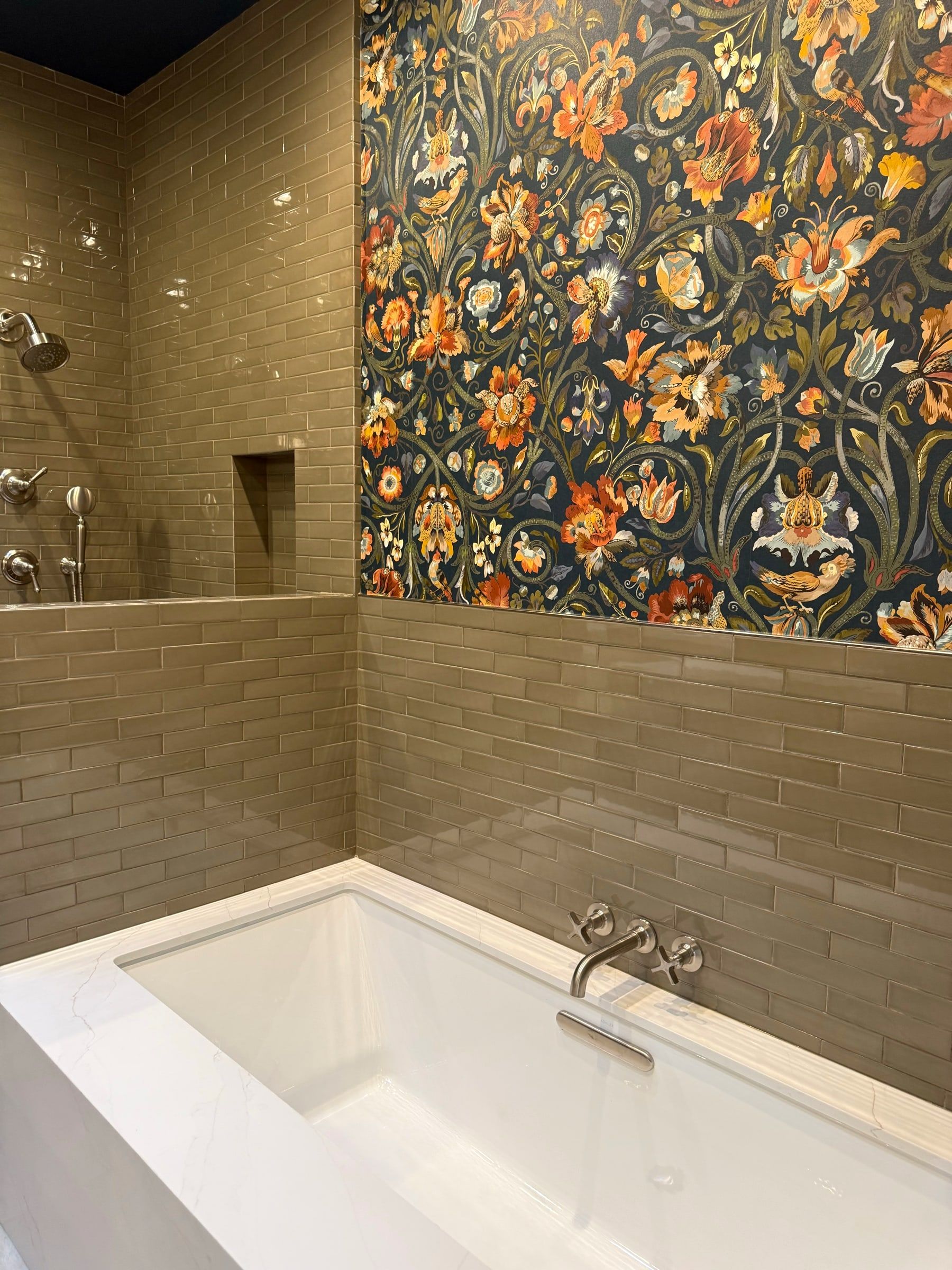 Freshly cleaned bathroom after a remodel, with a deep white soaking tub and floral wallpaper