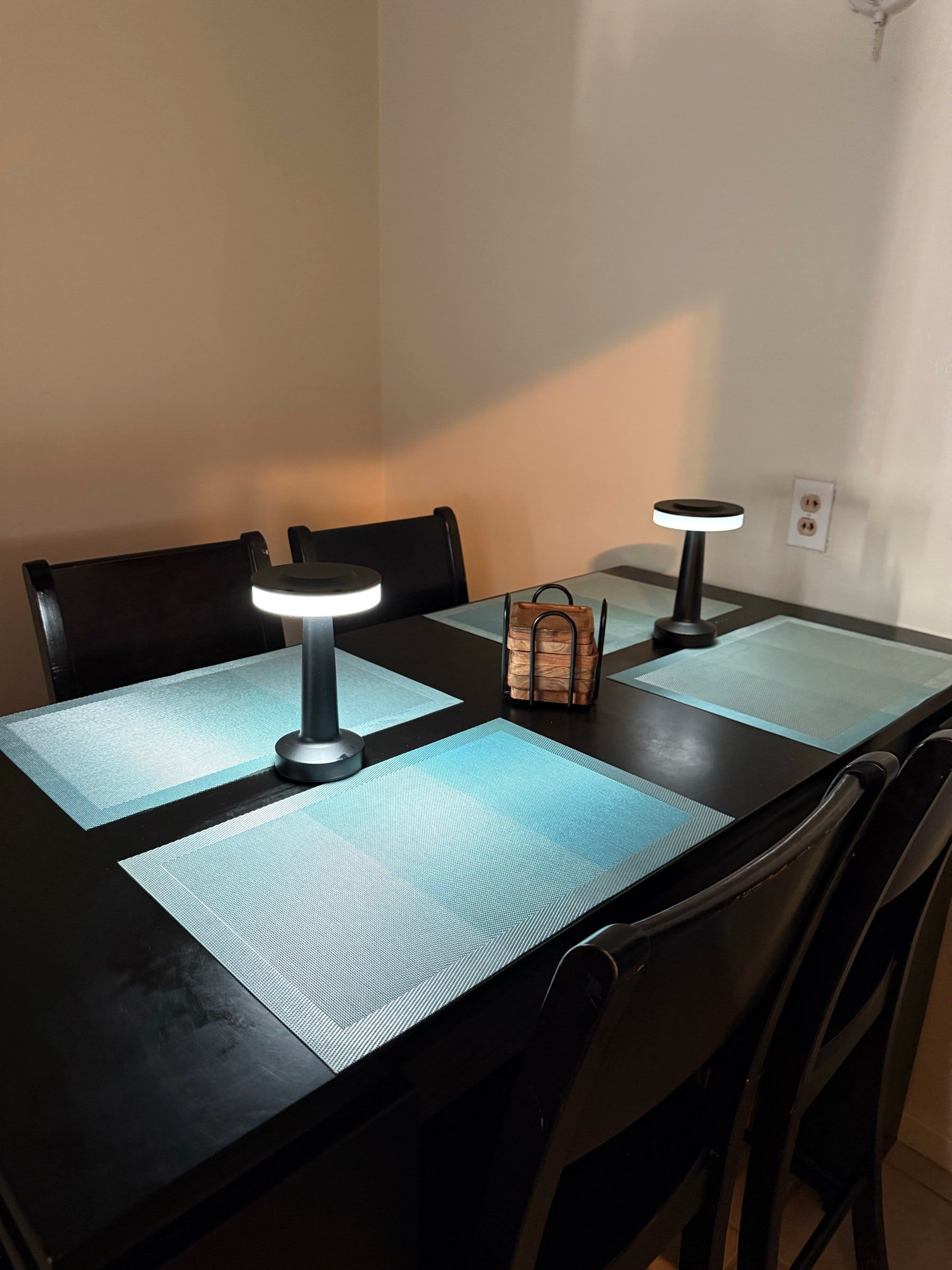 Clean dining table set with placemats and soft lamps